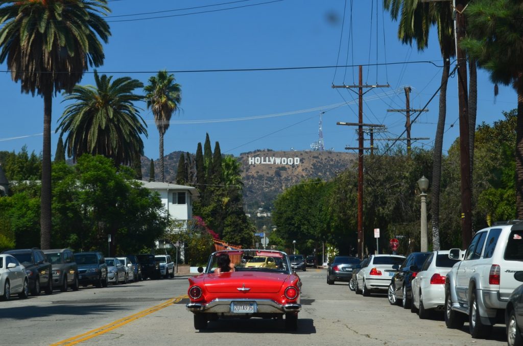 a red car driving down a street