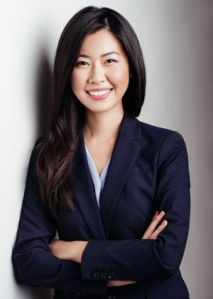 a person smiling and wearing a suit