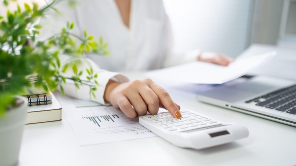 women on a desk with a calculator