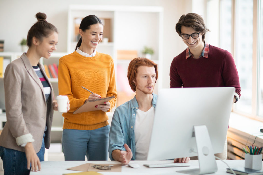 employees looking over a desktop