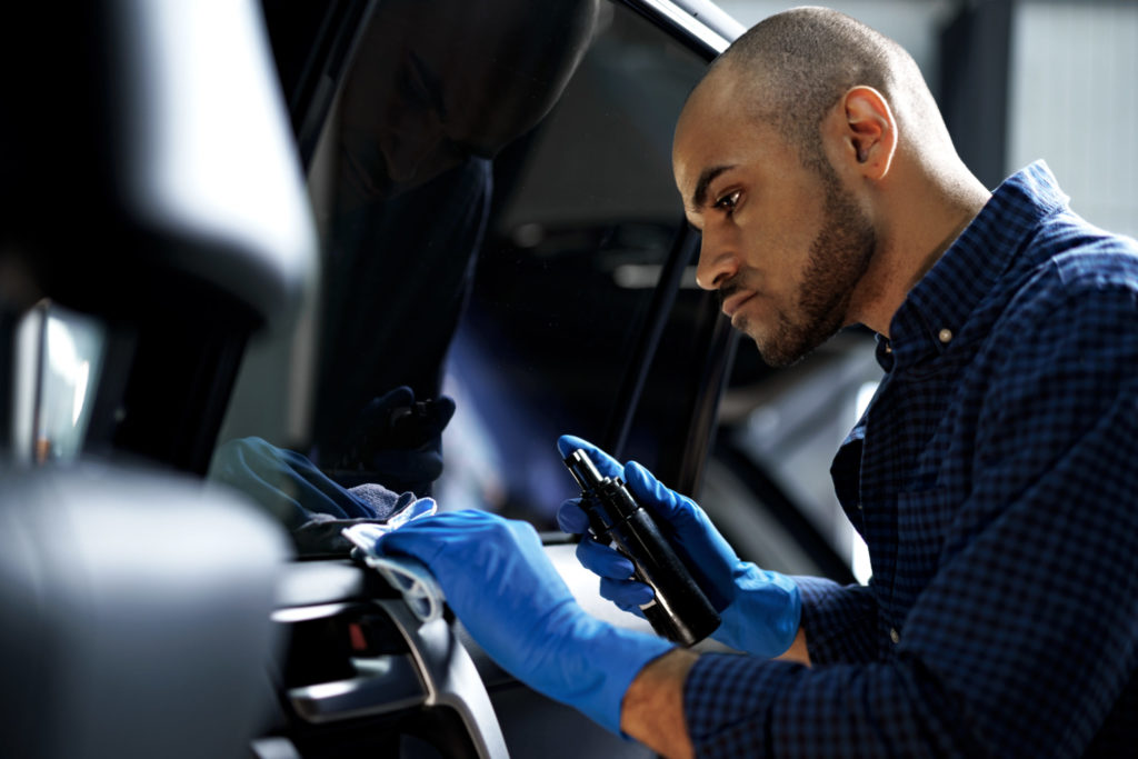 African American man car service worker applying nano coating on a car