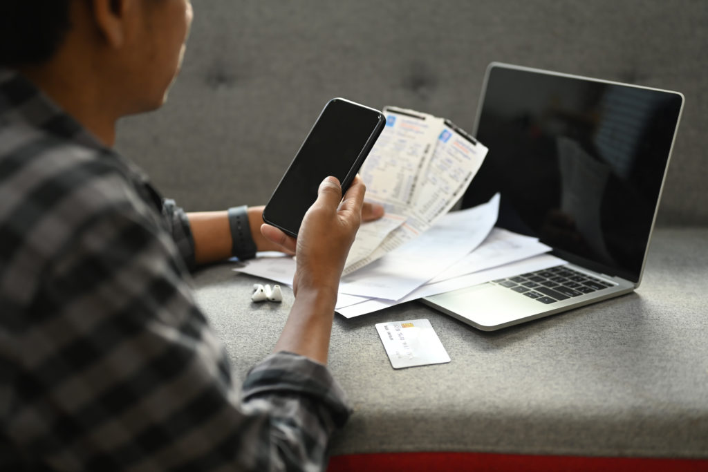 Side view young man calculating household expenses expenditures, paying electricity bills.