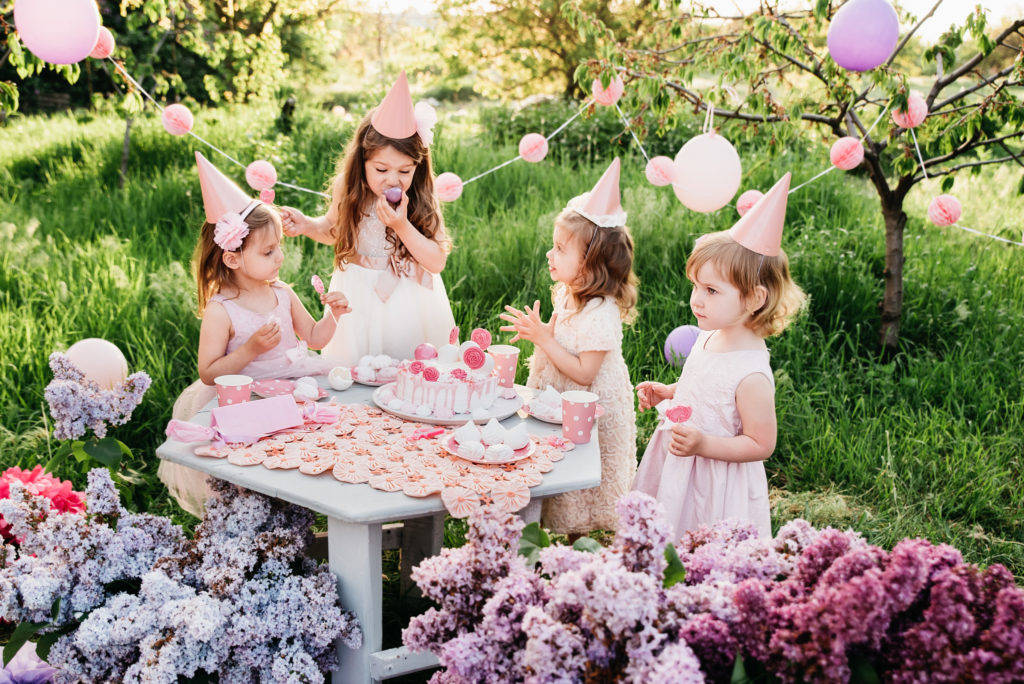 Summer outdoor kids birthday party. Group of happy Children celebrating birthday in park